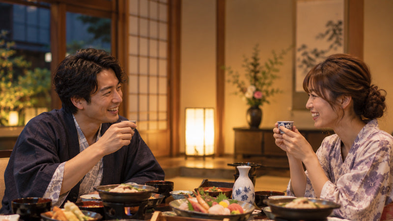 旅館で浴衣を着て食事をする二人
